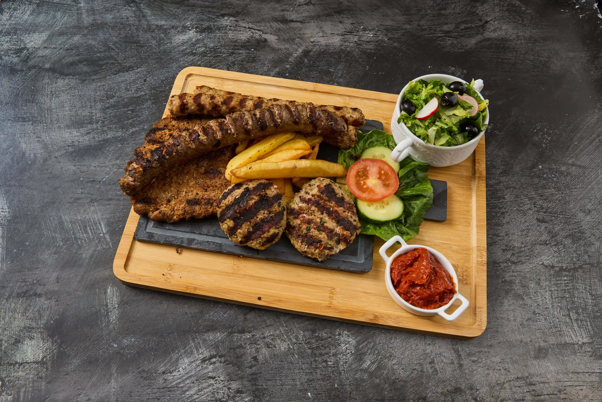 Gegrillte Balkan-Köfte und Kebaptsche auf heißer Grillplatte Bei Milen